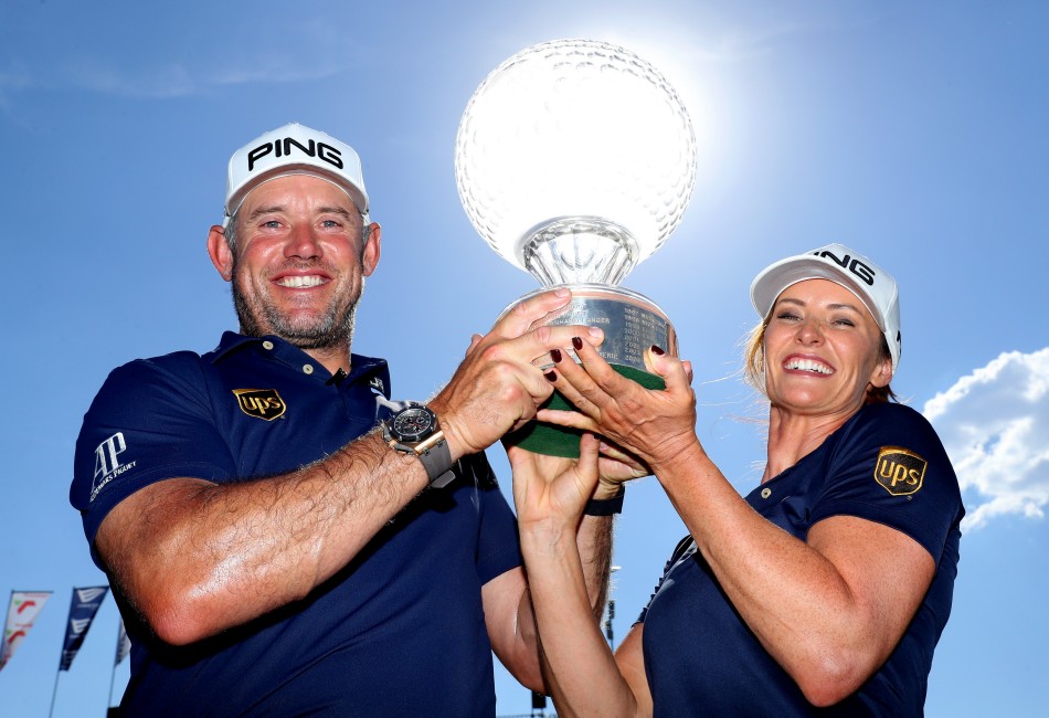 Lee Westwood and his partner and caddie, Helen Storey, lift the famous crystal trophy after his victory in the Nedbank Golf Challenge hosted by Gary Player.